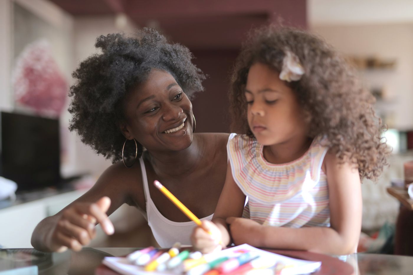A mother and daughter drawing together at home